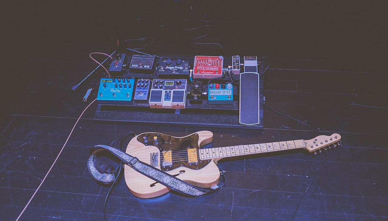 Gitara typu Telecaster i zestaw efektów na pedalboardzie.